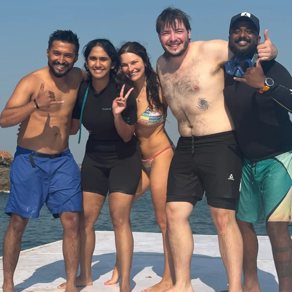 Smiling divers in wetsuits on the FlyingFish boat at Grande Island, Goa