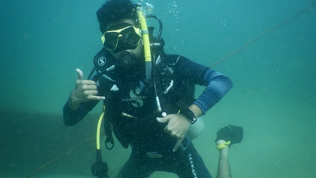 Diver in a Scubapro wetsuit giving a shaka sign near the descent line